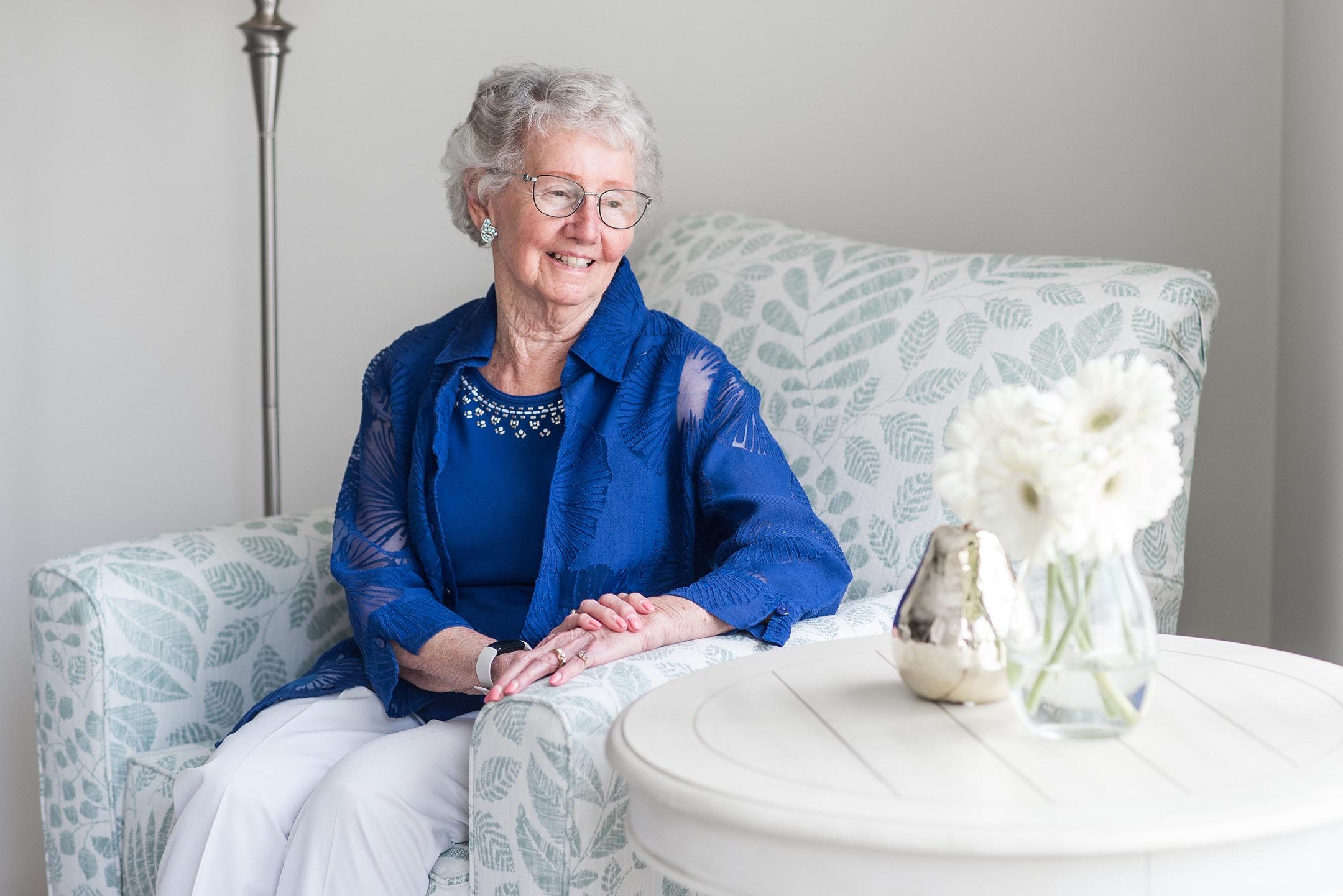 Senior woman sitting in armchair in retirement home suite